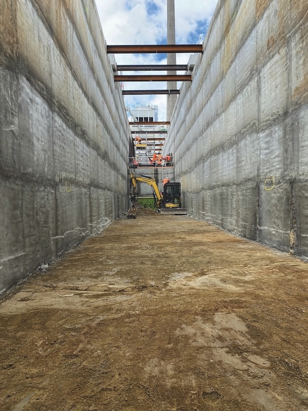 Deep excavation for the services tunnel progressed in stages to maintain access across the operating hospital campus.